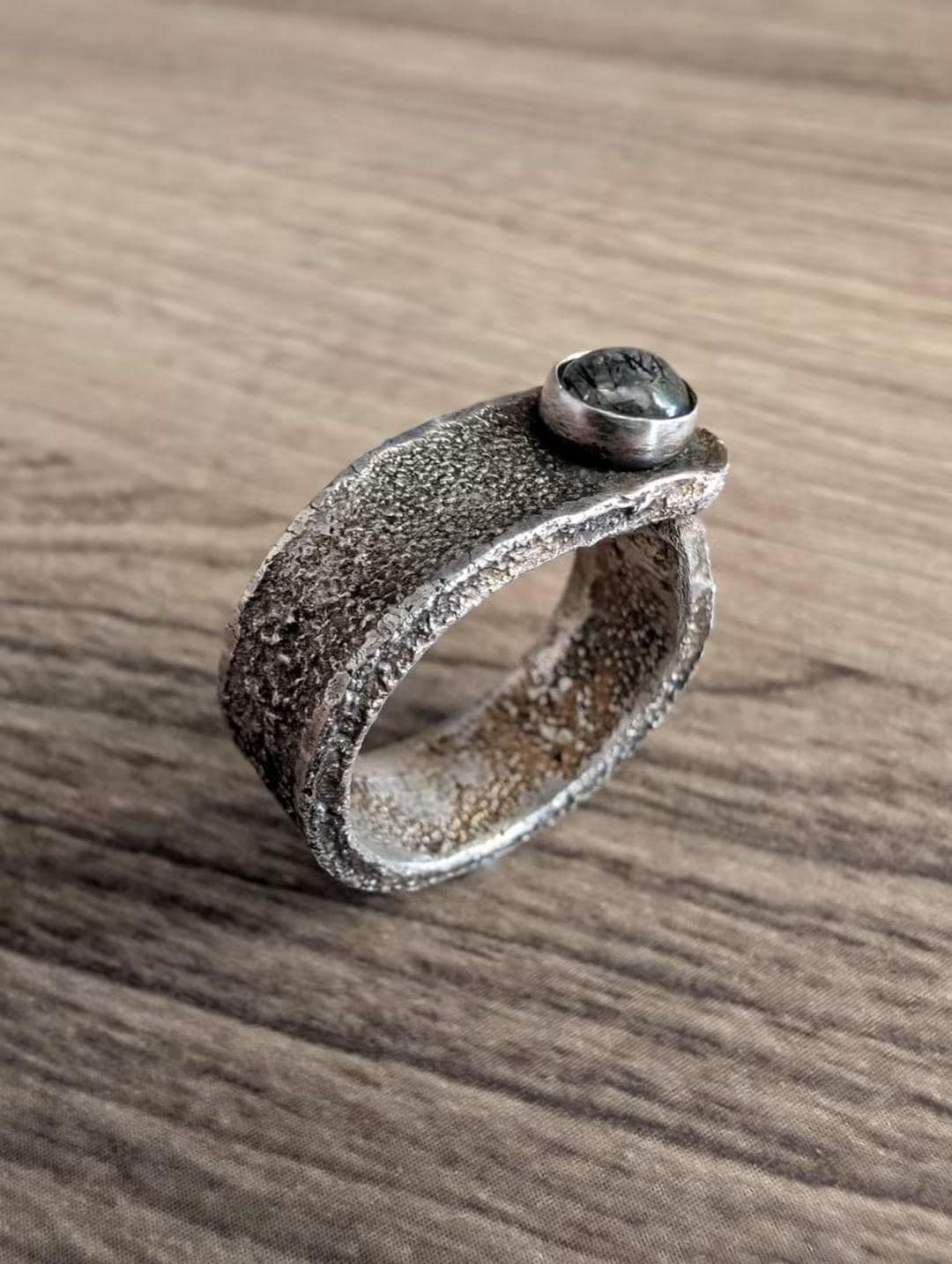 Canyon Band: wide textured sterling silver band with a round bezel-set tourmalinated quartz cabochon.