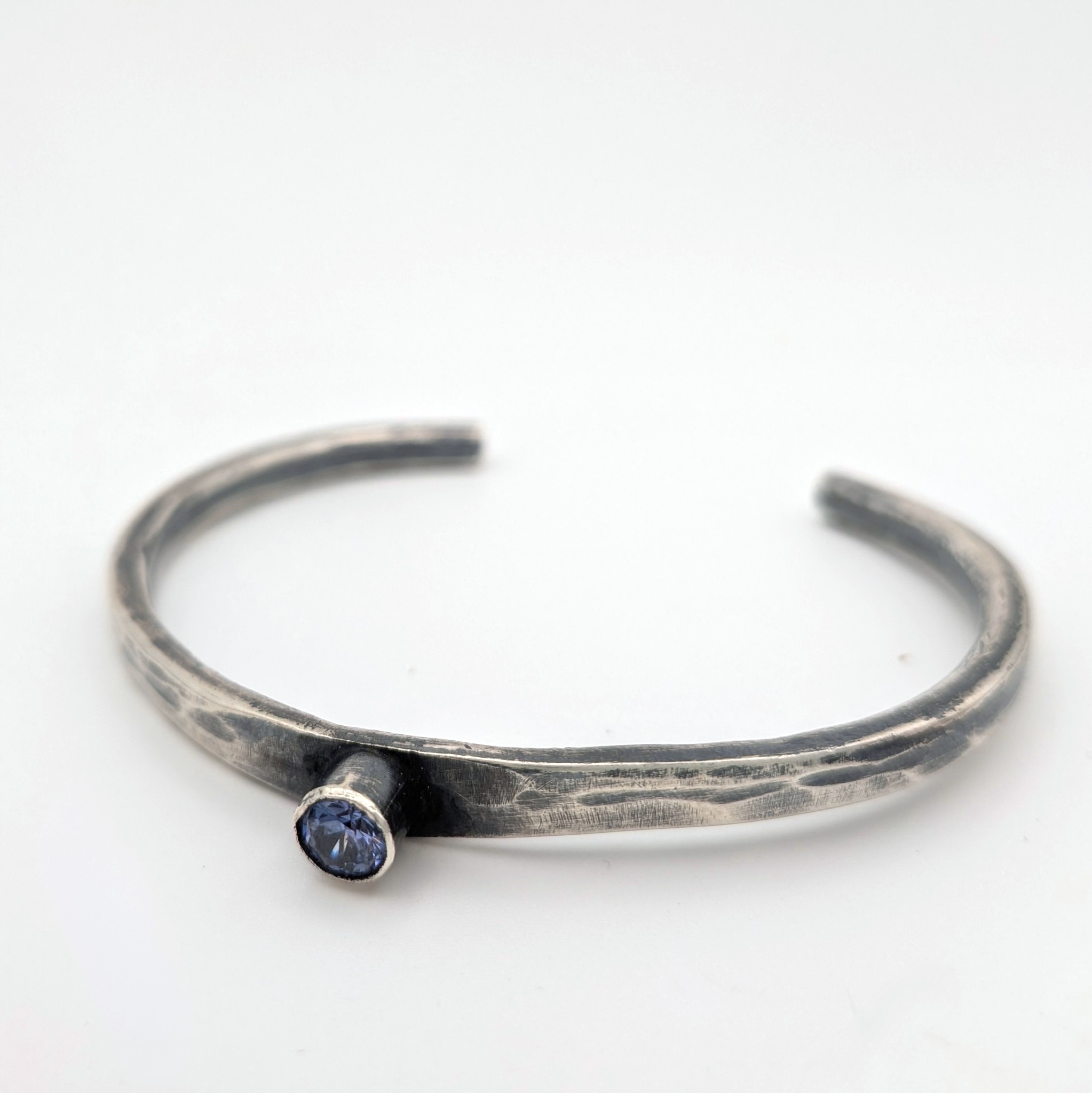 Horizon Cuff: slender sterling silver cuff with a faceted periwinkle cubic zirconia.