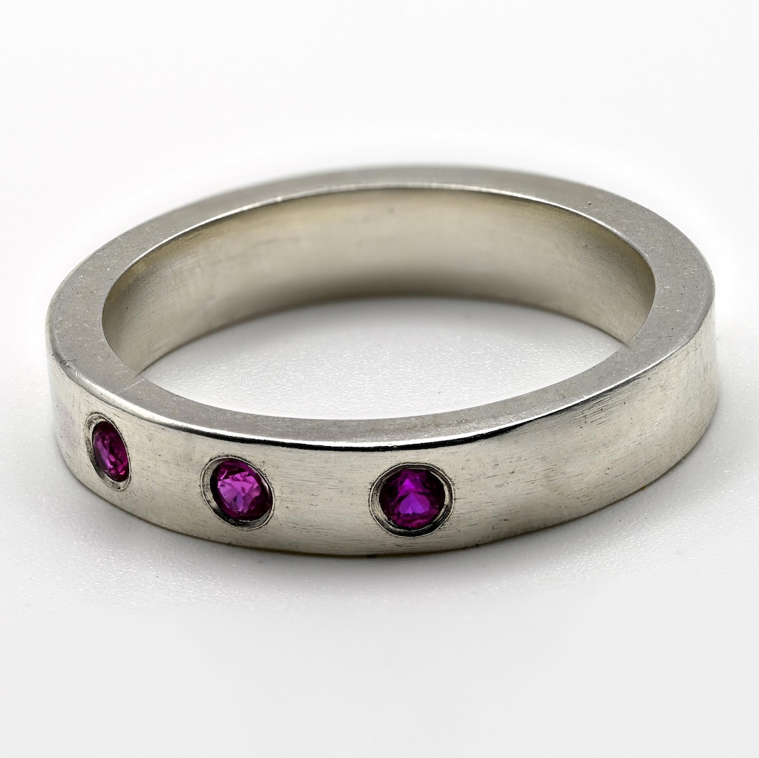 Sterling silver band with flush-set lab ruby stones.