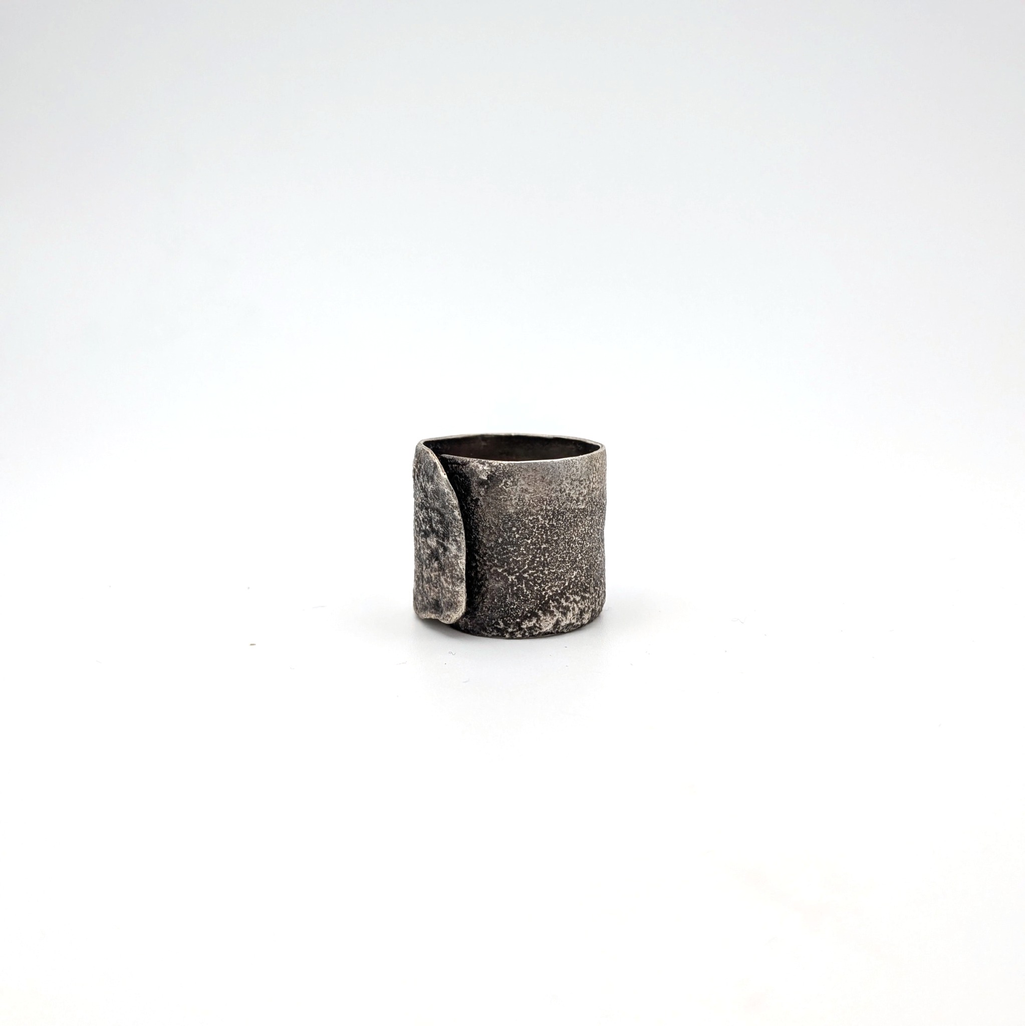 Serra Band: wide sculptural sterling silver wrap band with a heat-textured surface.